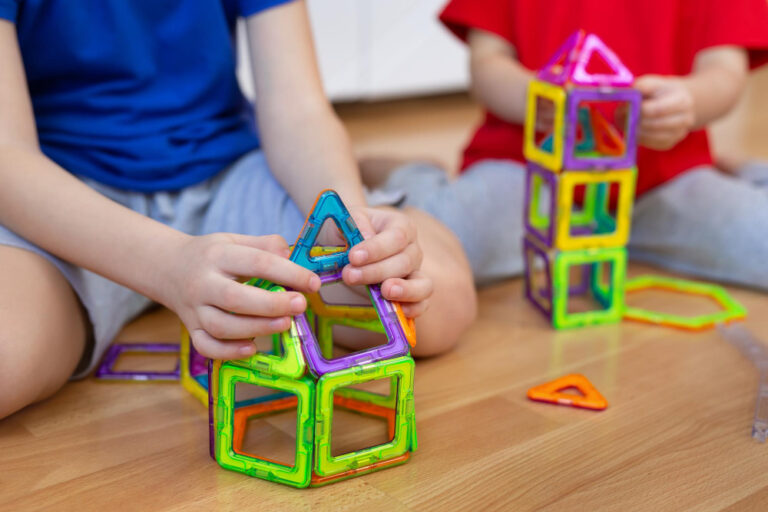 Brother and sister playing with magnetic construction toy